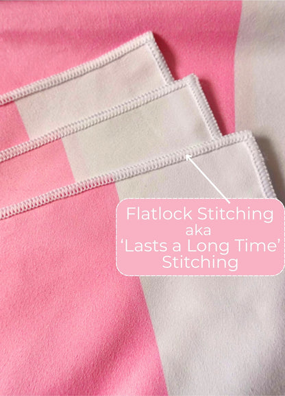 Close-up of fabric with flatlock stitching on a pink and white towel