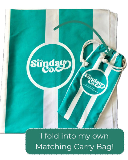 Green and white striped towel with matching carry bag featuring 'The Sunday Co.' logo on a white background.