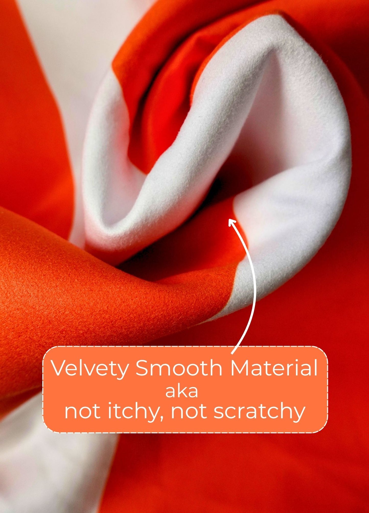 Close-up of red and white fabric with a label indicating 'Velvety Smooth Material' and 'not itchy, not scratchy'.